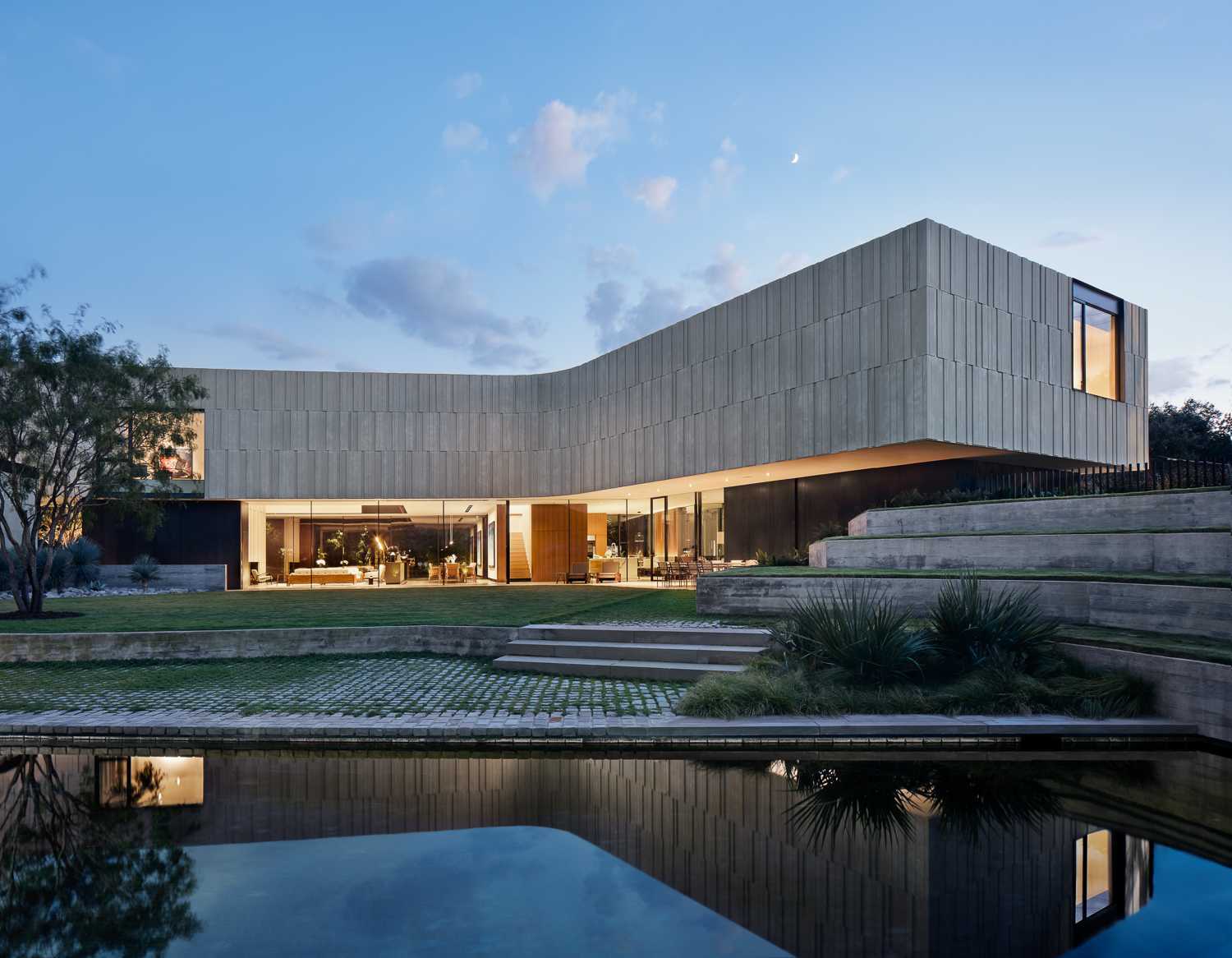 A modern home with a curved design and 40ft long wall of sliding glass doors.